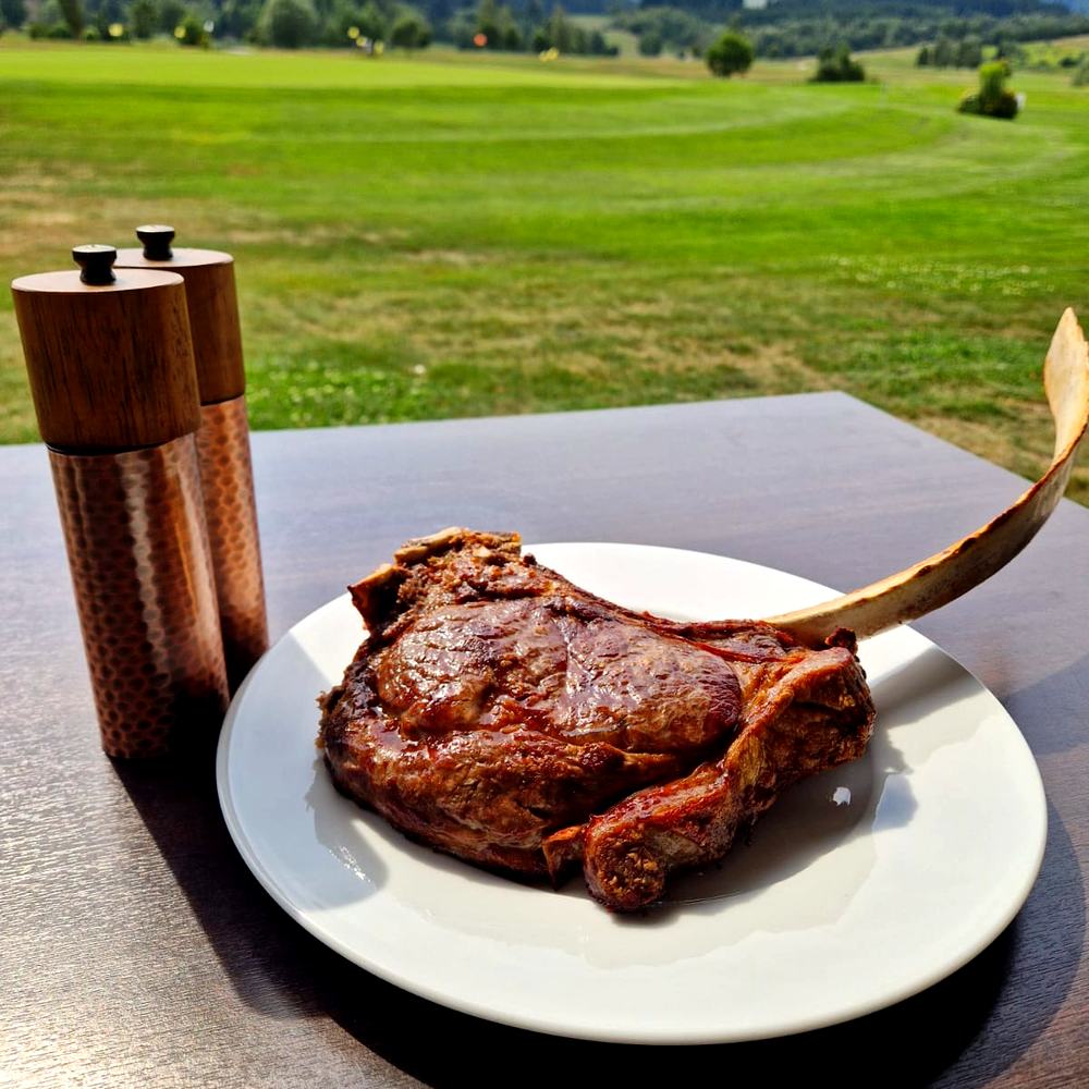 Steak vom eigenen Hof, dahinter der Blick über den Platz